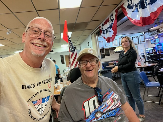 Veteran and volunteer smile happliy for the camera