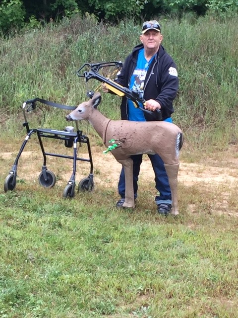 veteran poses with his crossbow and decoy target at the range