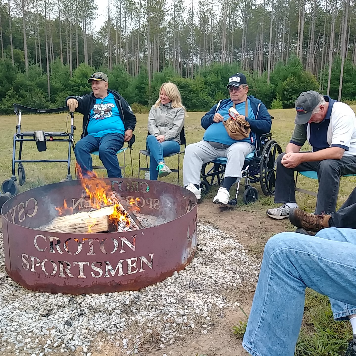 a group of veterans sit and converse around a campfire at the croton facility
