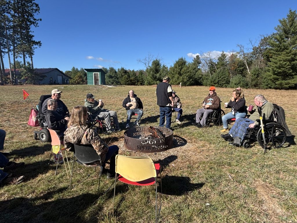 group of veterans sit around a campfire at the Croton facility