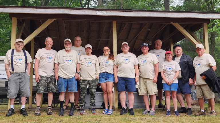 Group photo of veterans and organization members gathered for a fishing trip