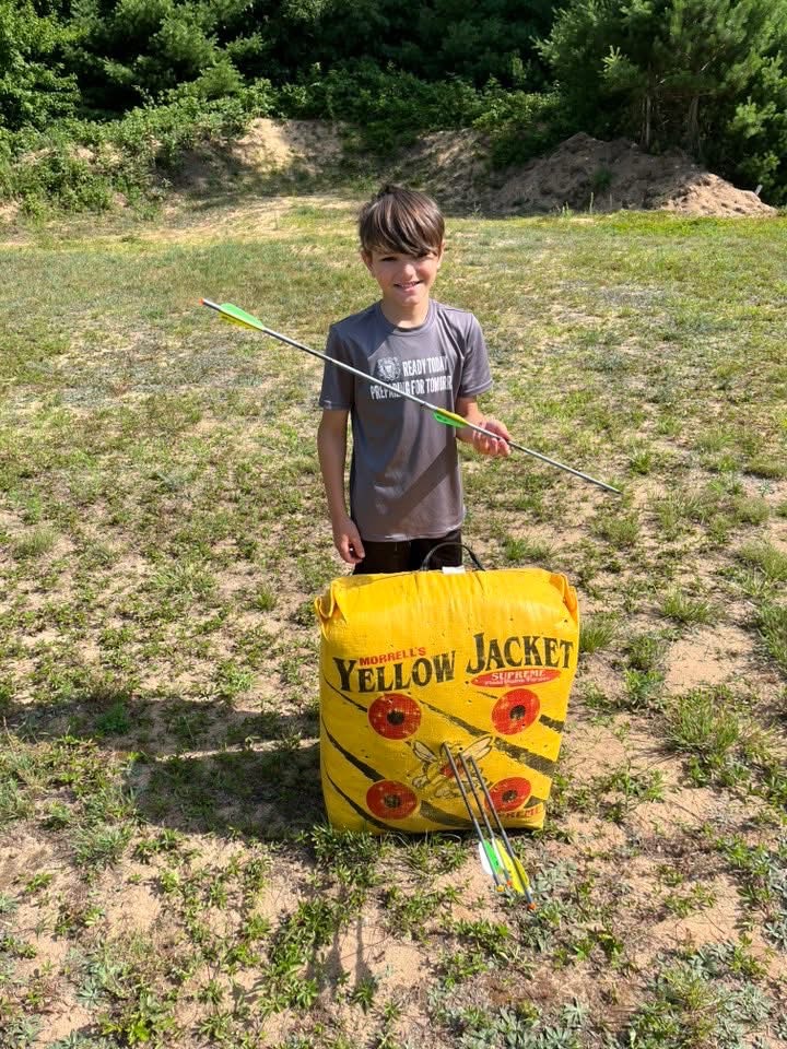 young archer stands holding his split arrow